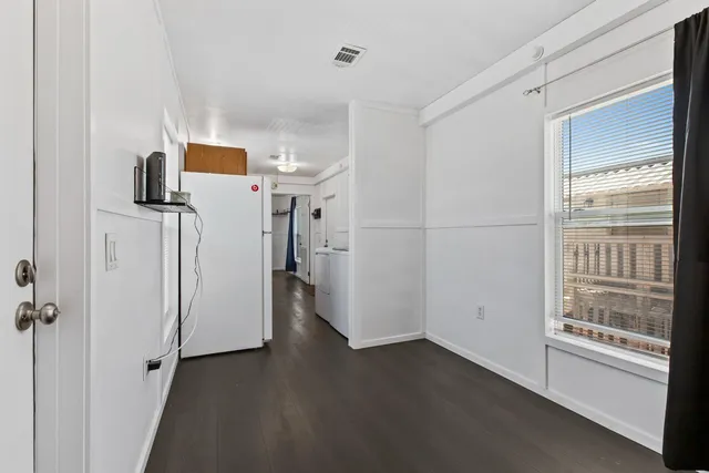 a view of empty room with wooden floor and window