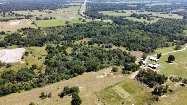 an aerial view of a houses with outdoor space and trees