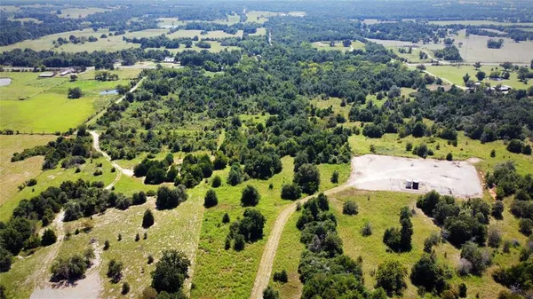 an aerial view of residential houses with outdoor space and trees