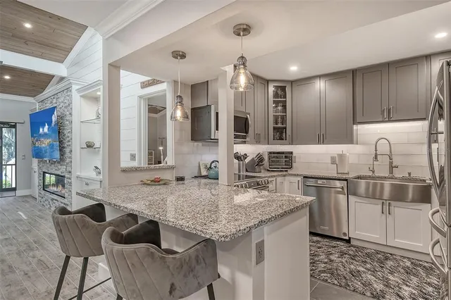 a kitchen with stainless steel appliances granite countertop a sink and cabinets