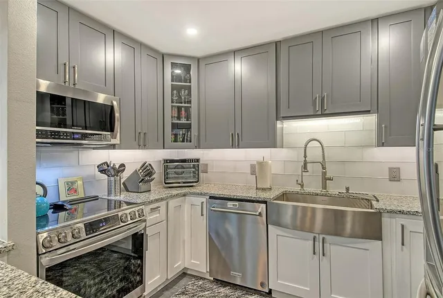 a kitchen with stainless steel appliances granite countertop a sink stove oven and refrigerator