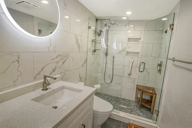 a bathroom with a sink a toilet and shower