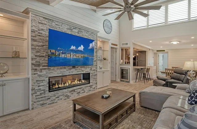 a living room with furniture a flat screen tv and a fireplace