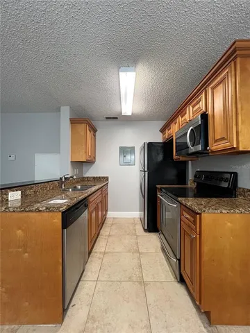 a kitchen with stainless steel appliances granite countertop a stove a sink and a microwave