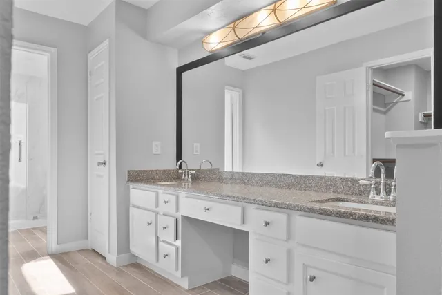 a bathroom with a granite countertop sink and a mirror