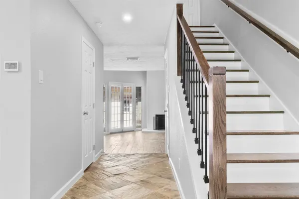 a view of a hallway with wooden floor and entryway