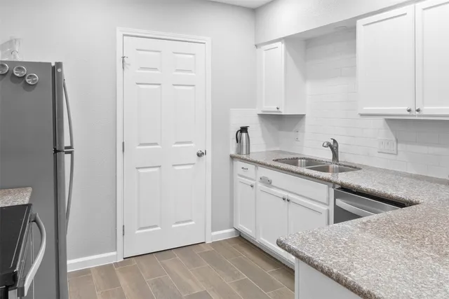 a kitchen with white cabinets and sink