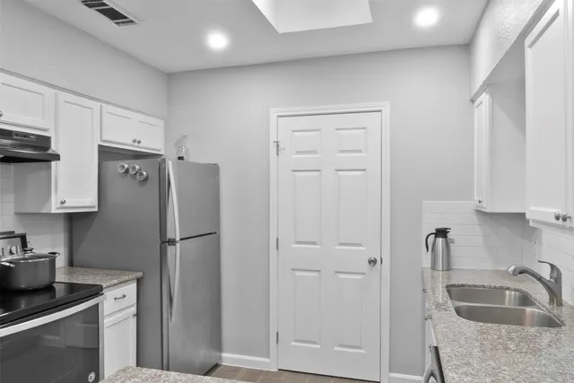 a kitchen with a refrigerator a sink and cabinets