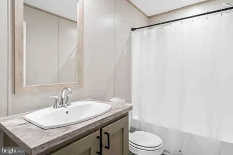 a bathroom with a sink a toilet and a mirror