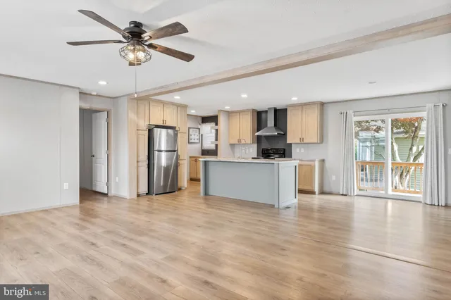 a view of a kitchen with stainless steel appliances wooden floor and a window