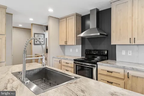 a kitchen with granite countertop a stove sink and cabinets