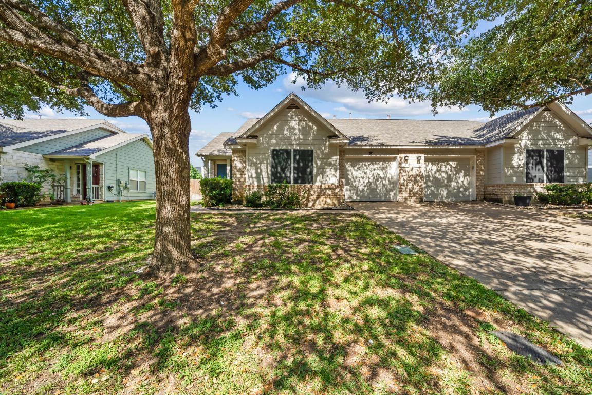 162 Prairie Springs Loop Georgetown, TX 78626 - Photo 1 of 1 Ranch-style house with an attached garage, brick siding, driveway, and a front yard