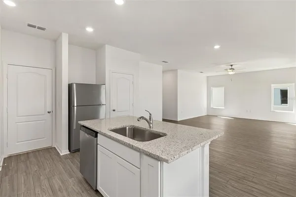 a kitchen with stainless steel appliances granite countertop a sink and a refrigerator