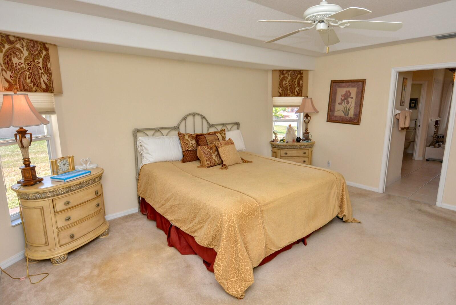 2041 Southwest Villanova Road Port St. Lucie, FL 34953 - Photo 18 of 42 a bedroom with a bed and a chandelier