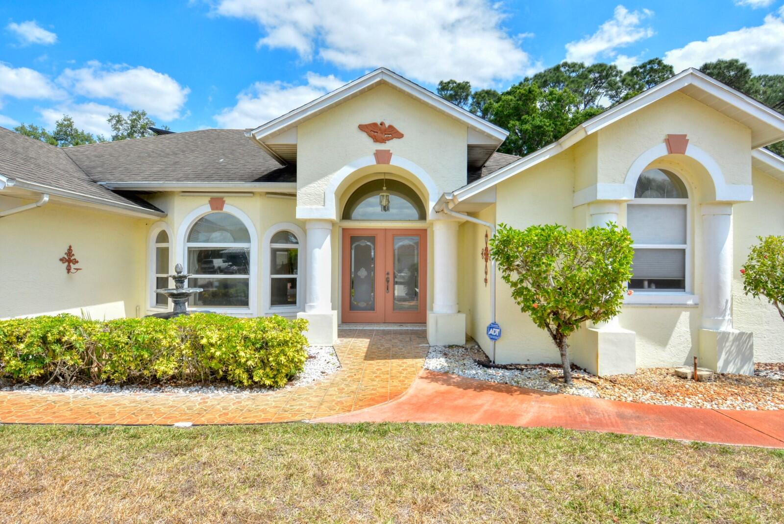 2041 Southwest Villanova Road Port St. Lucie, FL 34953 - Photo 2 of 42 a front view of a house with garden