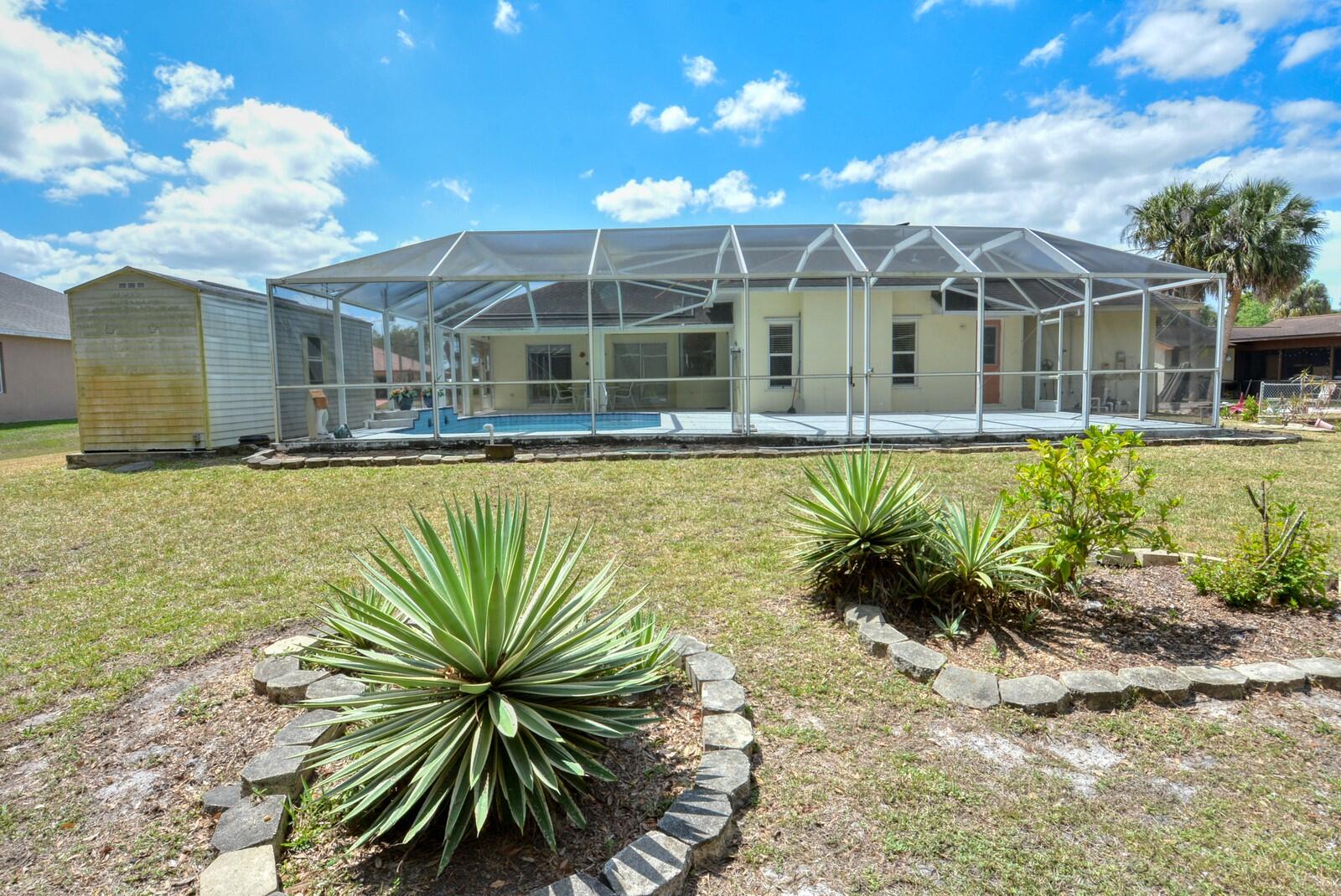 2041 Southwest Villanova Road Port St. Lucie, FL 34953 - Photo 41 of 42 a view of a swimming pool with a chair and tables in the patio