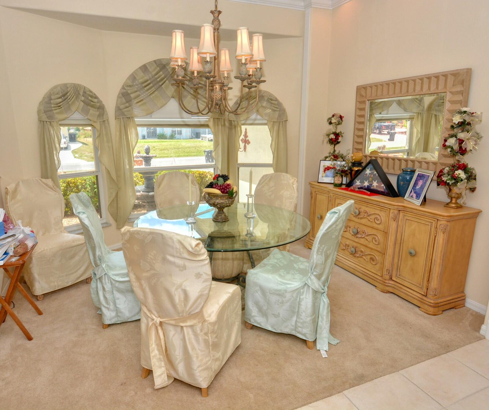2041 Southwest Villanova Road Port St. Lucie, FL 34953 - Photo 5 of 42 a dining room with wooden floor a chandelier a glass table and chairs