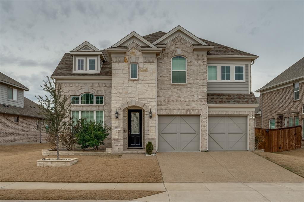 View of front of house featuring concrete driveway, roof with shingles, a garage, stone siding, and brick siding