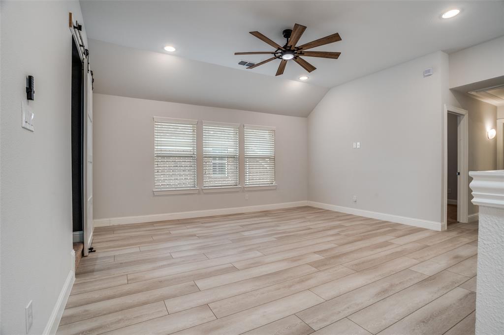 2811 Killdeer Trail Prosper, TX 75078 - Photo 18 of 36 Spare room with ceiling fan, a barn door, light wood-type flooring, recessed lighting, and lofted ceiling