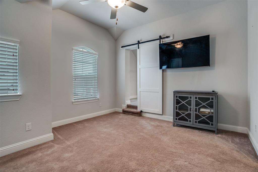 2811 Killdeer Trail Prosper, TX 75078 - Photo 22 of 36 Unfurnished bedroom with a barn door, light colored carpet, a ceiling fan, and vaulted ceiling