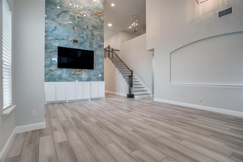 2811 Killdeer Trail Prosper, TX 75078 - Photo 5 of 36 Unfurnished living room featuring light wood finished floors and a high ceiling