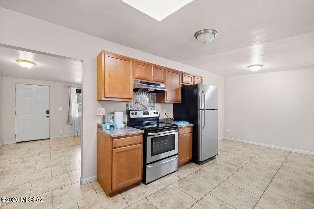 1301 West Kleindale Road Tucson, AZ 85705 - Photo 3 of 27 a kitchen with stainless steel appliances granite countertop a stove a sink and a refrigerator
