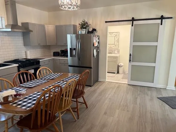 a kitchen with granite countertop a refrigerator and a stove top oven