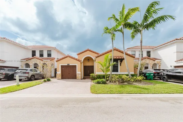 a front view of a house with a garden and parking