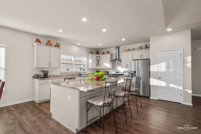 a kitchen with granite countertop white cabinets and white appliances