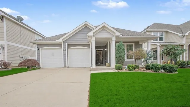 a front view of a house with a yard and potted plants