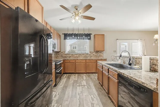a large kitchen with a sink and refrigerator