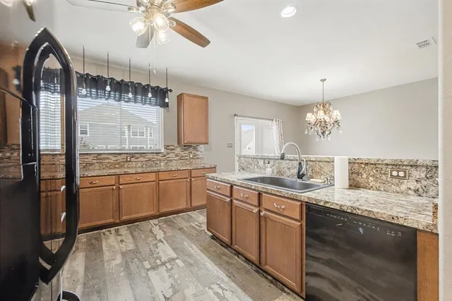 a large kitchen with a lot of counter space and wooden floor