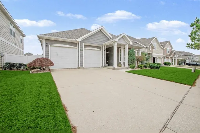 a view of white house with a big yard and potted plants