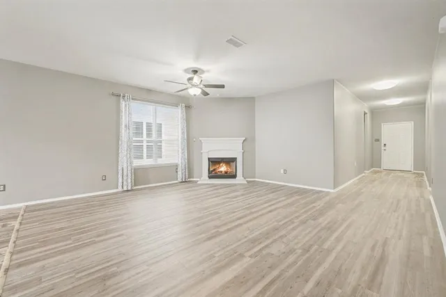 a view of an empty room with a fireplace and a window