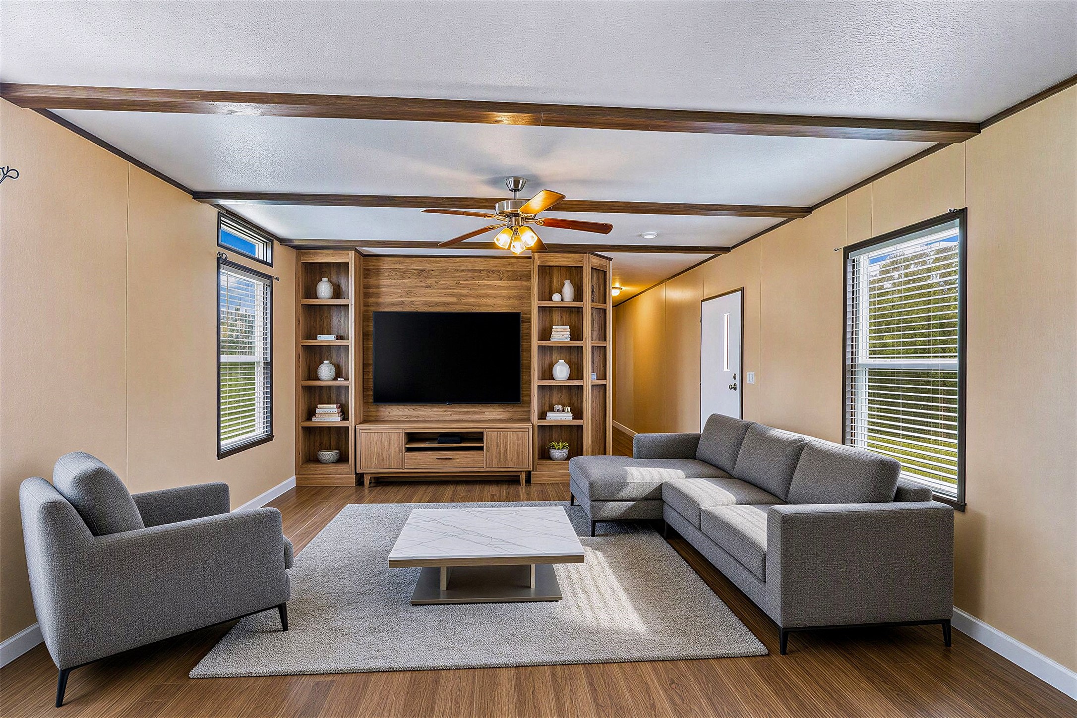 935 Lower Red Rock Road Bastrop, TX 78602 - Photo 2 of 25 Virtually staged - Living area featuring laminate flooring, a ceiling fan and exposed ceiling beams, ideal for entertaining.