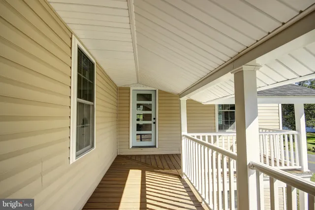 a view of a house with a barbeque and wooden stairs