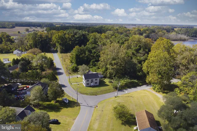 an aerial view of a house with a yard and lake view