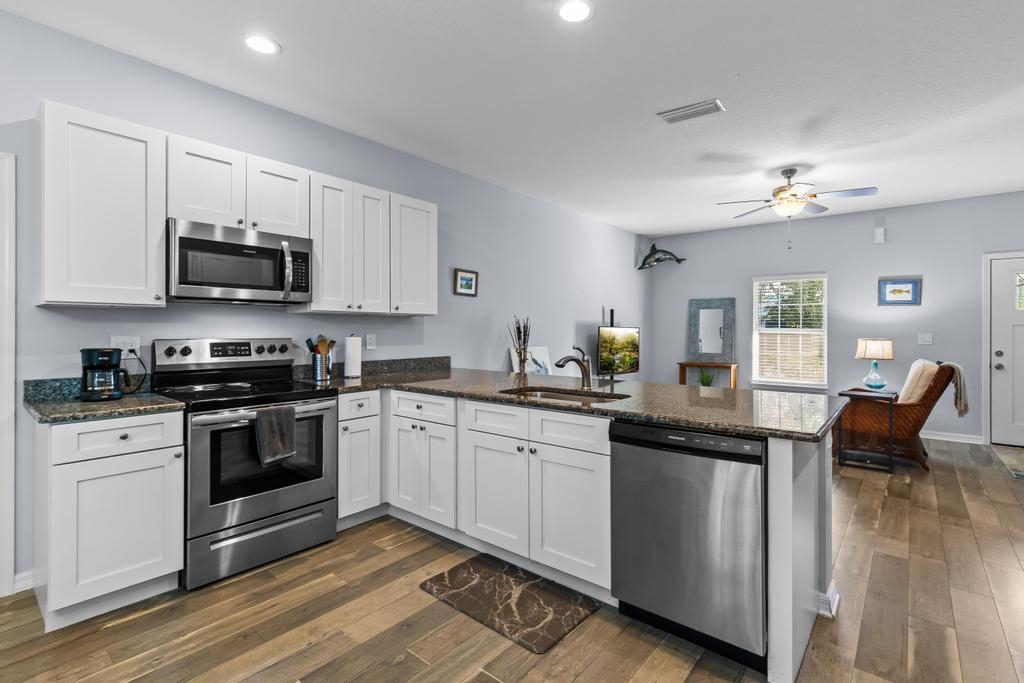 124 Dory Road St. Augustine, FL 32086 - Photo 12 of 39 a kitchen with stainless steel appliances granite countertop a stove top oven a sink dishwasher and white cabinets