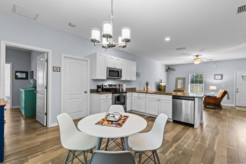 124 Dory Road St. Augustine, FL 32086 - Photo 15 of 39 a view of a dining room with furniture a chandelier and wooden floor