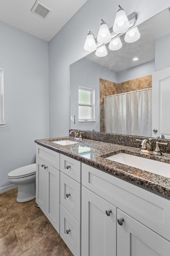124 Dory Road St. Augustine, FL 32086 - Photo 19 of 39 a bathroom with a granite countertop sink a toilet and a mirror