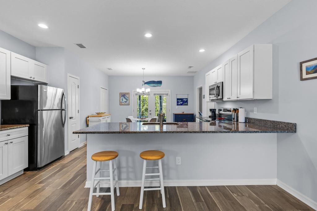 124 Dory Road St. Augustine, FL 32086 - Photo 9 of 39 a kitchen with stainless steel appliances granite countertop a table chairs refrigerator and sink