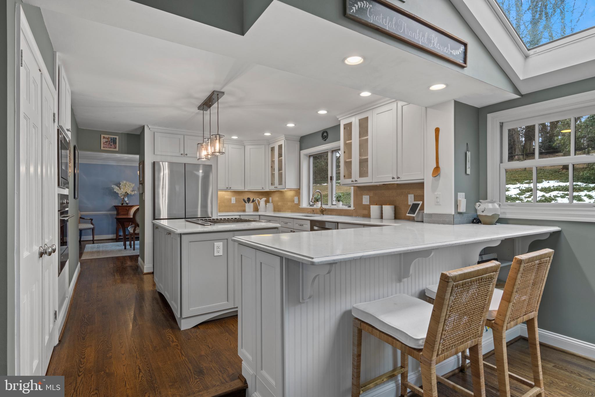 152 Hunters Lane Devon, PA 19333 - Photo 24 of 57 a kitchen with kitchen island granite countertop wooden floors and white cabinets