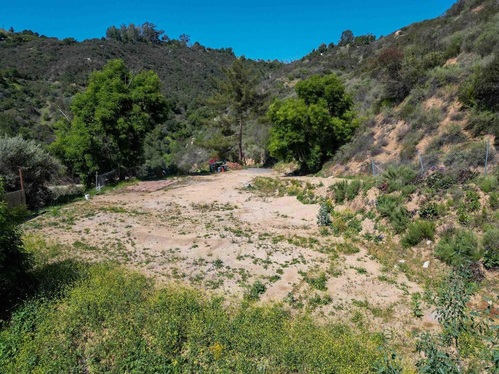 9932 Gomez Creek Road Fallbrook, CA 92028 - Photo 14 of 30 a view of a dry yard with trees in the background