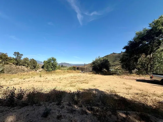 a view of a dry yard with mountains in the background