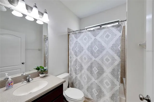 a bathroom with a sink vanity mirror and toilet