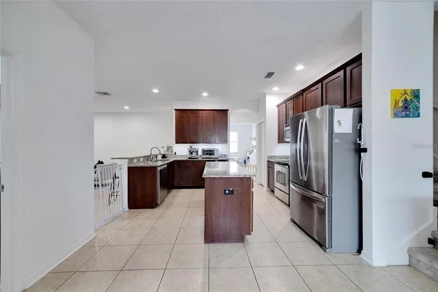 a kitchen with stainless steel appliances granite countertop a refrigerator and a sink