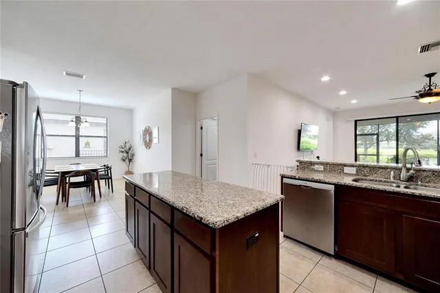 a kitchen with granite countertop sink table and chairs