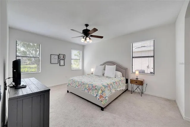 a bedroom with a bed a chandelier and a window