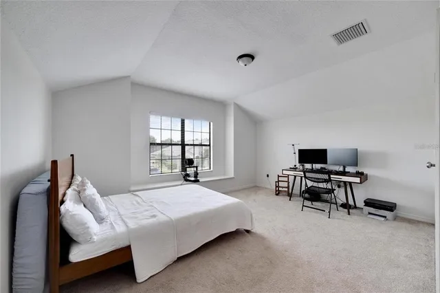 a bedroom with a bed and large windows