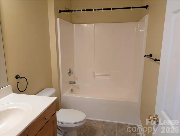 a bathroom with a toilet shower vanity and a sink